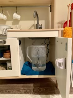 an open cabinet with a pitcher inside of it