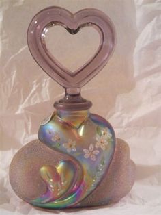 a glass vase with a heart on top