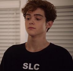 a young man wearing a black shirt with slc on it