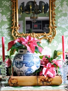 a blue and white vase sitting on top of a wooden table next to a mirror