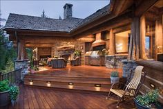 a wooden deck with lights on it next to an outdoor kitchen and grill area in the background