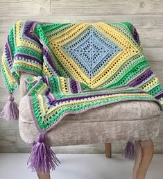 a crocheted blanket sitting on top of a bench