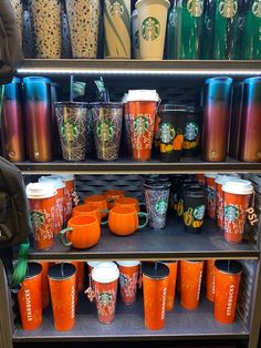 there are many starbucks cups on the shelf