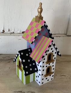 a small house made out of cardboard with polka dots on the roof and windows in different colors