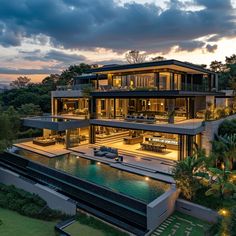 an aerial view of a modern house with pool in the foreground and trees on the other side