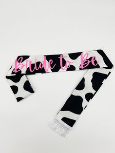 a cow print scarf with the words,'bride to be'printed on it