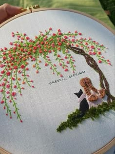 someone is holding up a hand embroidered picture