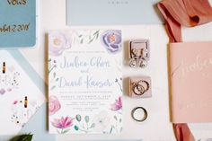 the wedding stationery is laid out on top of the table, including rings and napkins