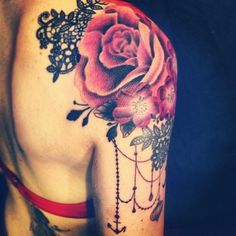 the back of a woman's shoulder with roses and laces on her arm