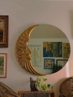 a mirror that is on the wall above a chair and some pictures in a room