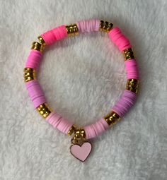 Heishi/clay beaded bracelet: Pink heart heishi/clay beaded bracelet -good quality -very stretchy -one size: about 6.5 inches (can stretch to around 8 inches) This bracelet includes various shades of pink heishi/clay beads, gold spacers, and a light pink heart charm upon very stretchy string.  Sizing: This bracelet comes in one size (measures about 6.5 inches) and is meant to fit people with small and medium size wrists. If you have a larger wrist than about 8 inches, then send me a message to ge Clay Bead Bracelet Ideas Hot Pink, Pink Clay Bead Phone Charm, Trendy Heishi Beads Stretch Bracelet, Pink Heishi Beads Stretch Bracelet For Friendship, Trendy Pink Heishi Beads Stretch Bracelet, Pink Heishi Beads Bracelets, Clay Bead Bracelet Pink, Bracelets Preppy, Valentines Bracelets