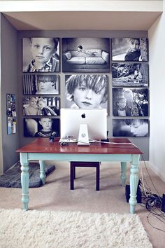 a desk with an apple computer on it in front of several black and white pictures