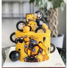 a yellow and black cake with wheels on it