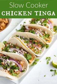 slow cooker chicken tinga on a white plate with limes and cilantro