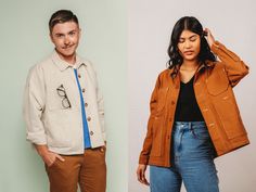 two people standing next to each other in front of a white wall and one is wearing a brown jacket