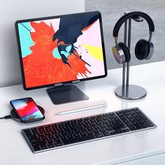 an apple desktop computer with headphones and a phone next to it on a desk