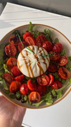 a salad with tomatoes, lettuce and sauce in a bowl