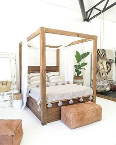 a bed sitting in the middle of a room next to two stools and a mirror