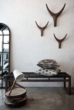 a white brick wall with three antlers on it