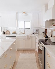 a kitchen with white cabinets and counter tops