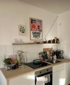 a kitchen with a stove top oven sitting next to a wall mounted art above it