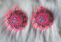 two pink and brown beaded earrings on white fur