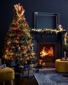 a decorated christmas tree in front of a fireplace