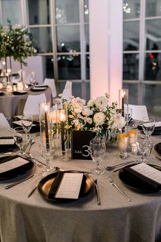 the table is set with silverware and candles for an elegant wedding reception or special event