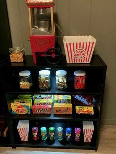 a shelf filled with snacks and popcorn on top of a wooden floor next to a wall