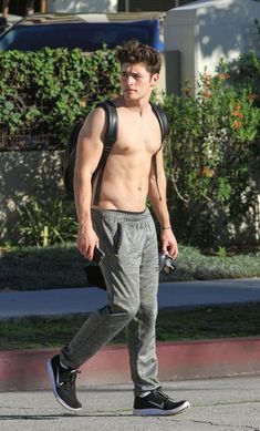 a shirtless young man walking down the street