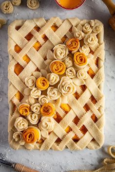 an apple pie with flowers on it and some other items around the edges, ready to be baked