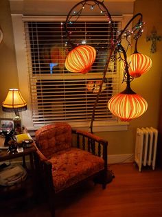 three lamps hanging from the ceiling above a chair in front of a radiator