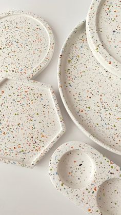 speckled dishes are arranged on a white surface