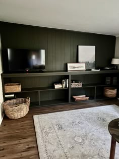 a living room with a large rug and tv on top of the entertainment center in it