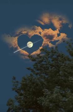 a heart shaped kite flying in the sky with trees and clouds behind it at night