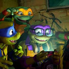 the teenage mutant turtles are playing with each other in front of a computer monitor and another character