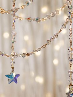 a star is hanging from a chain with beads