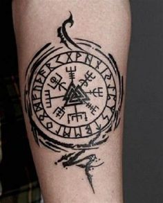 a tattoo on the arm of a person with a compass and other symbols in it