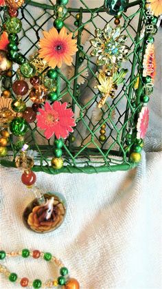 a green wire basket with flowers and beads