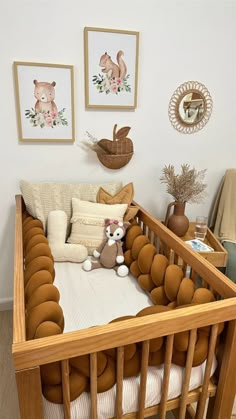 a baby crib with stuffed animals in it and pictures on the wall behind it