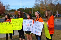 several girls holding signs and posing for the camera