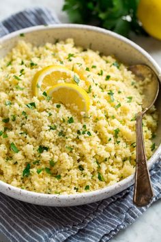 a bowl filled with rice and topped with lemon wedges