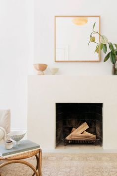 a living room with a fire place and white walls