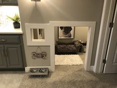 a dog house built into the side of a wall in a living room with grey walls