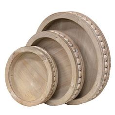 three wooden bowls with beaded trims are stacked on top of each other in front of a white background