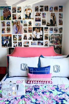 a bed topped with lots of pillows and pictures on the wall above it's headboard