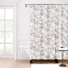 a bathroom with a shower curtain that has a black and white floral pattern on it