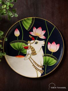 a decorative plate with an image of a unicorn and flowers painted on the front, sitting on a wooden table