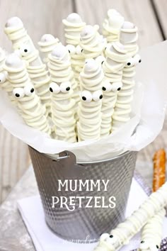 a bucket filled with white frosted pretzels sitting on top of a table