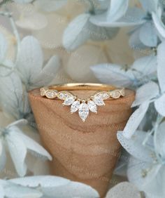 a close up view of a gold ring with three pear shaped diamonds on the side